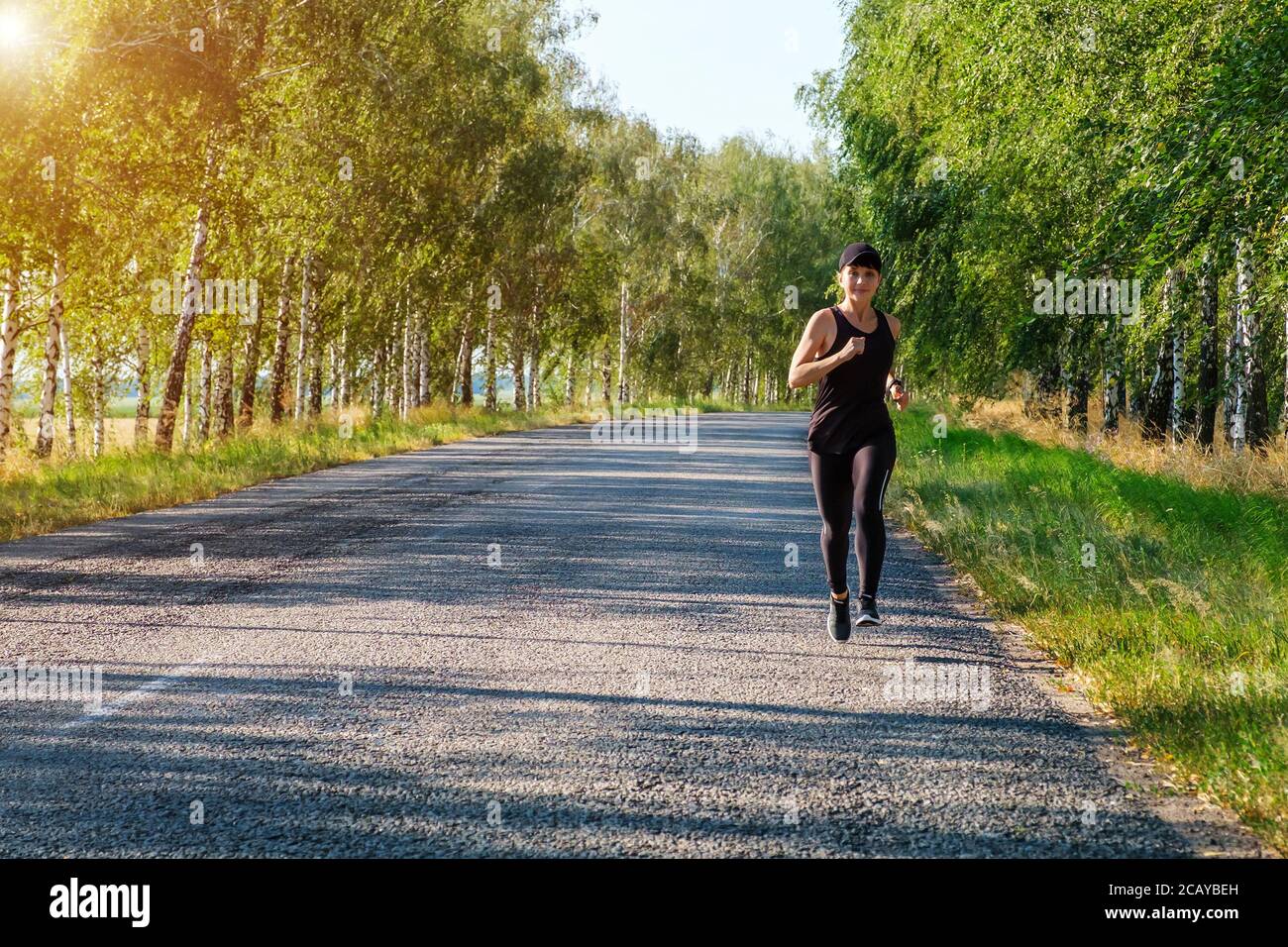 Young Fit Beautiful Girl Running Outdoor On A Dirt Road During