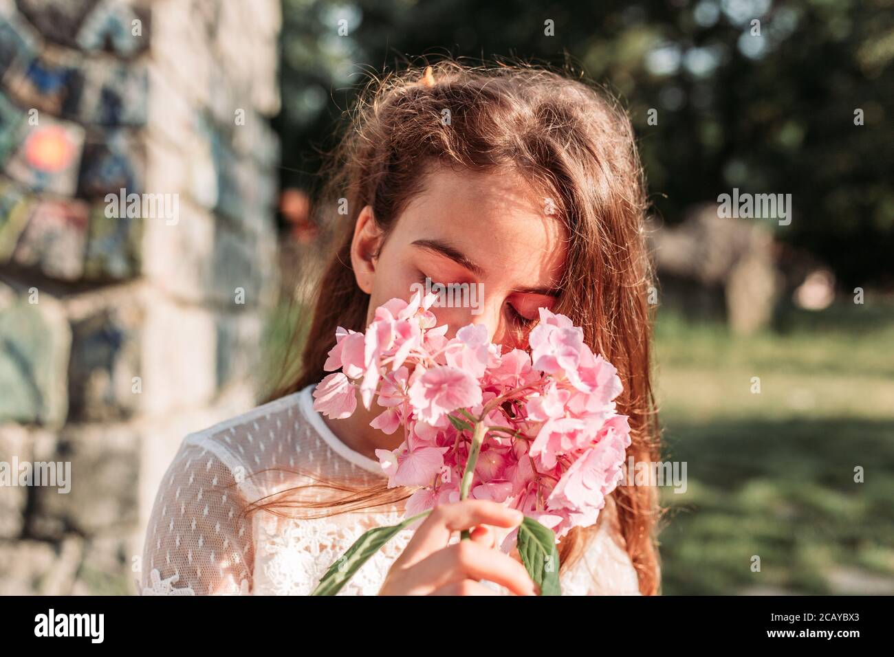Portrait of cute, little girl smelling flowers in her hands Stock Photo ...