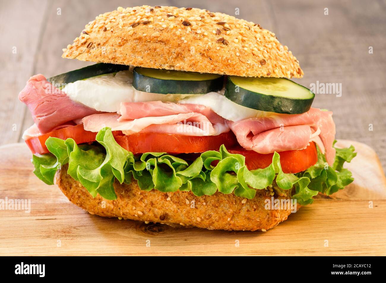 Rustic sandwich with ham, tomato, cucumber, mozzarella and green salad ...