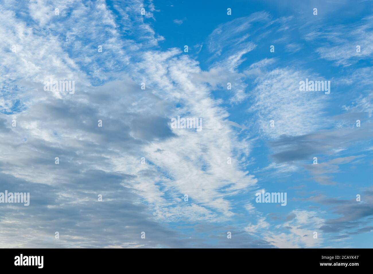 Light blue sky with white and grey clouds Stock Photo - Alamy