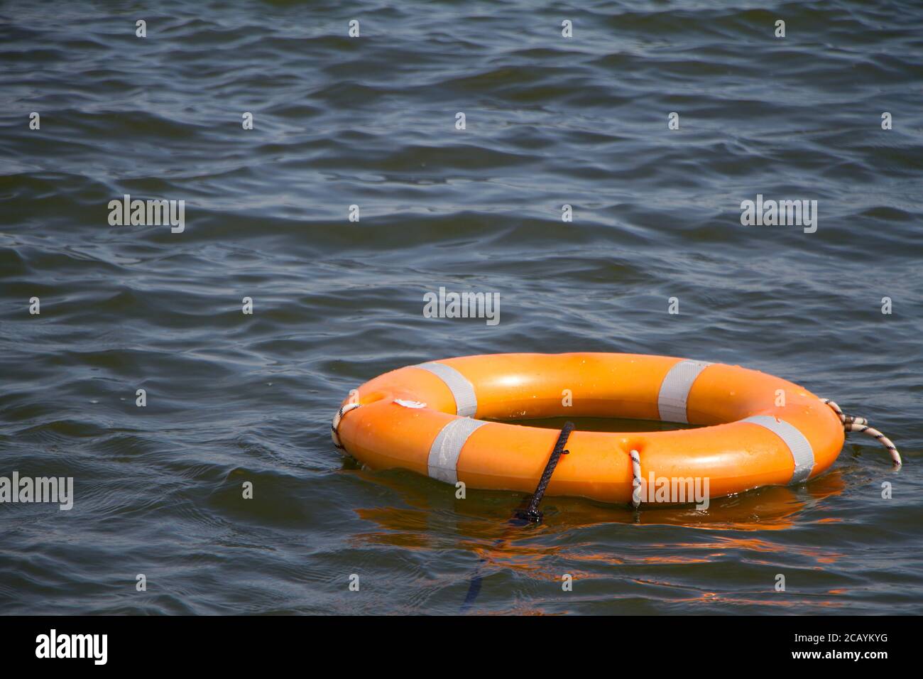 Orange life buoy on water surface as symbol of help and hope, selective focus Stock Photo