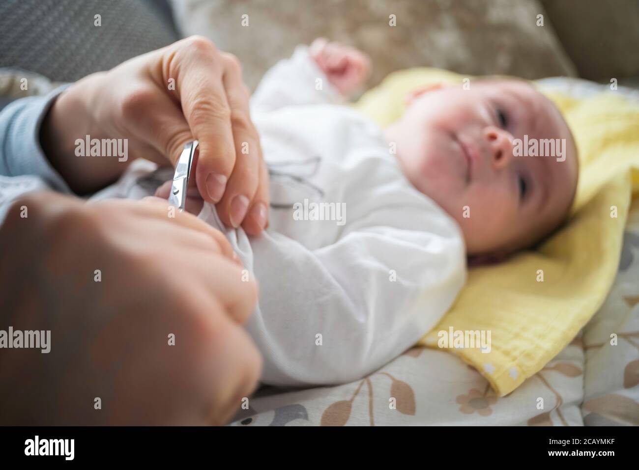 Mother trimming newborns nails on a bed Stock Photo Alamy