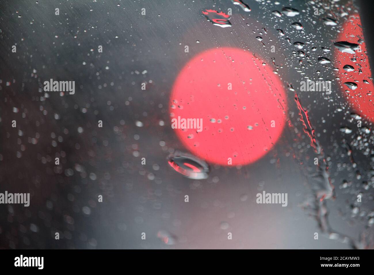 Close-up of glass with raindrops and light reflections, drops of water on car glass, selective focus Stock Photo