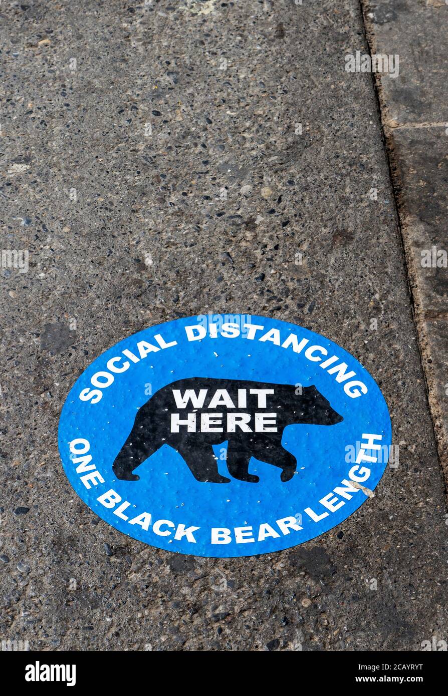 BANFF, CANADA - JULY 29, 2020: Social Distancing road pavement sticker to help visitors at popular Banff National Park to keep a safe distance when sh Stock Photo