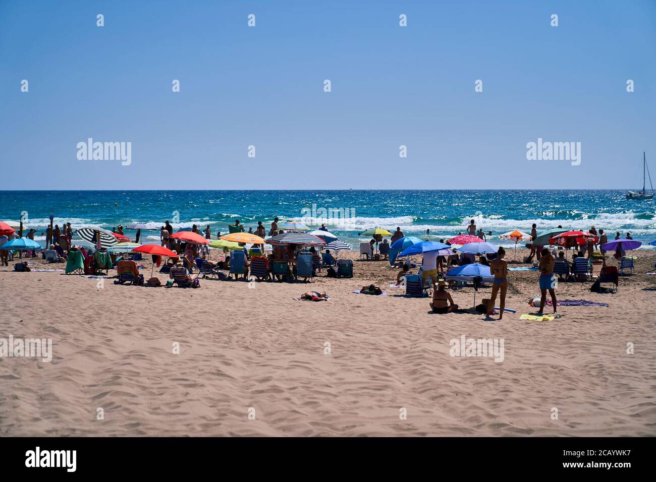 Sunseekers gathered with sunloungers and parasols, San Juan beach Alicante, Spain, Europe, July 2020 Stock Photo