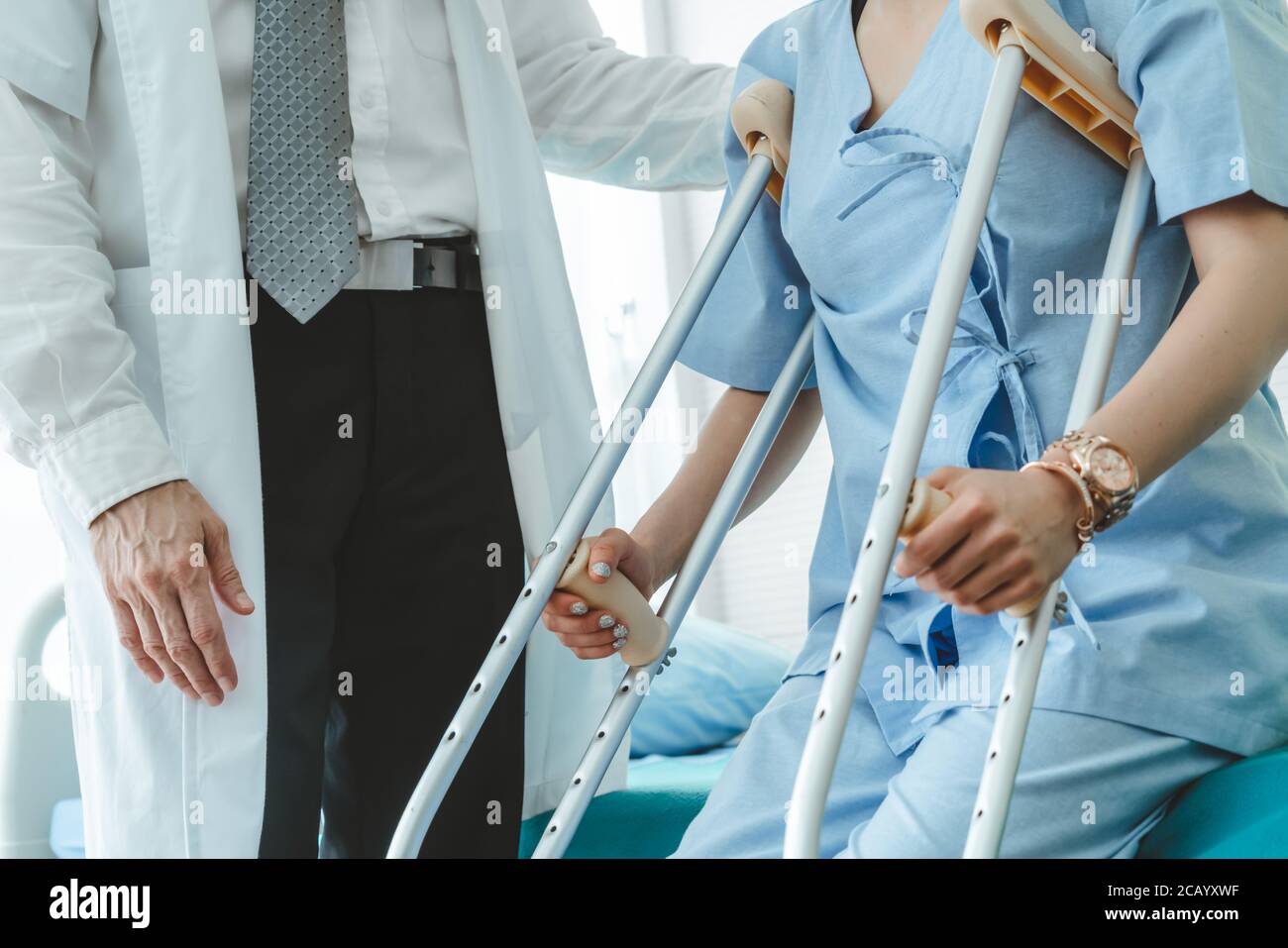 Doctor takes care of patient in crutch at hospital Stock Photo Alamy