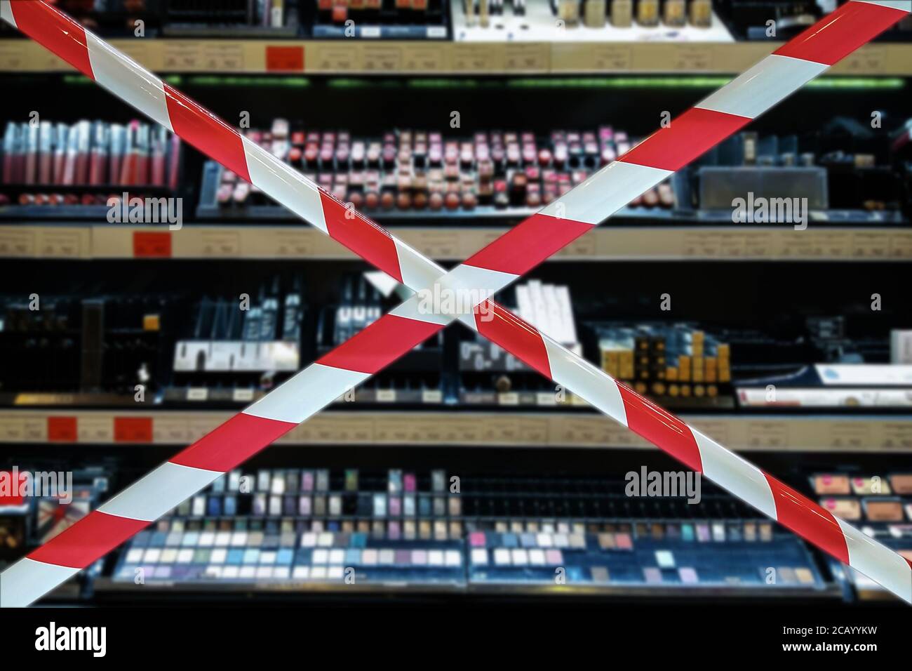 defocused shelves of decorative cosmetics forbidden for testing behind barrier tape cross Stock Photo