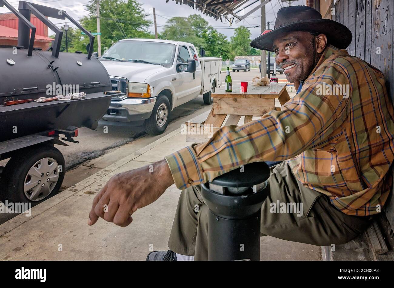 A man sits outside Red’s Blues Club and watches the people pass during