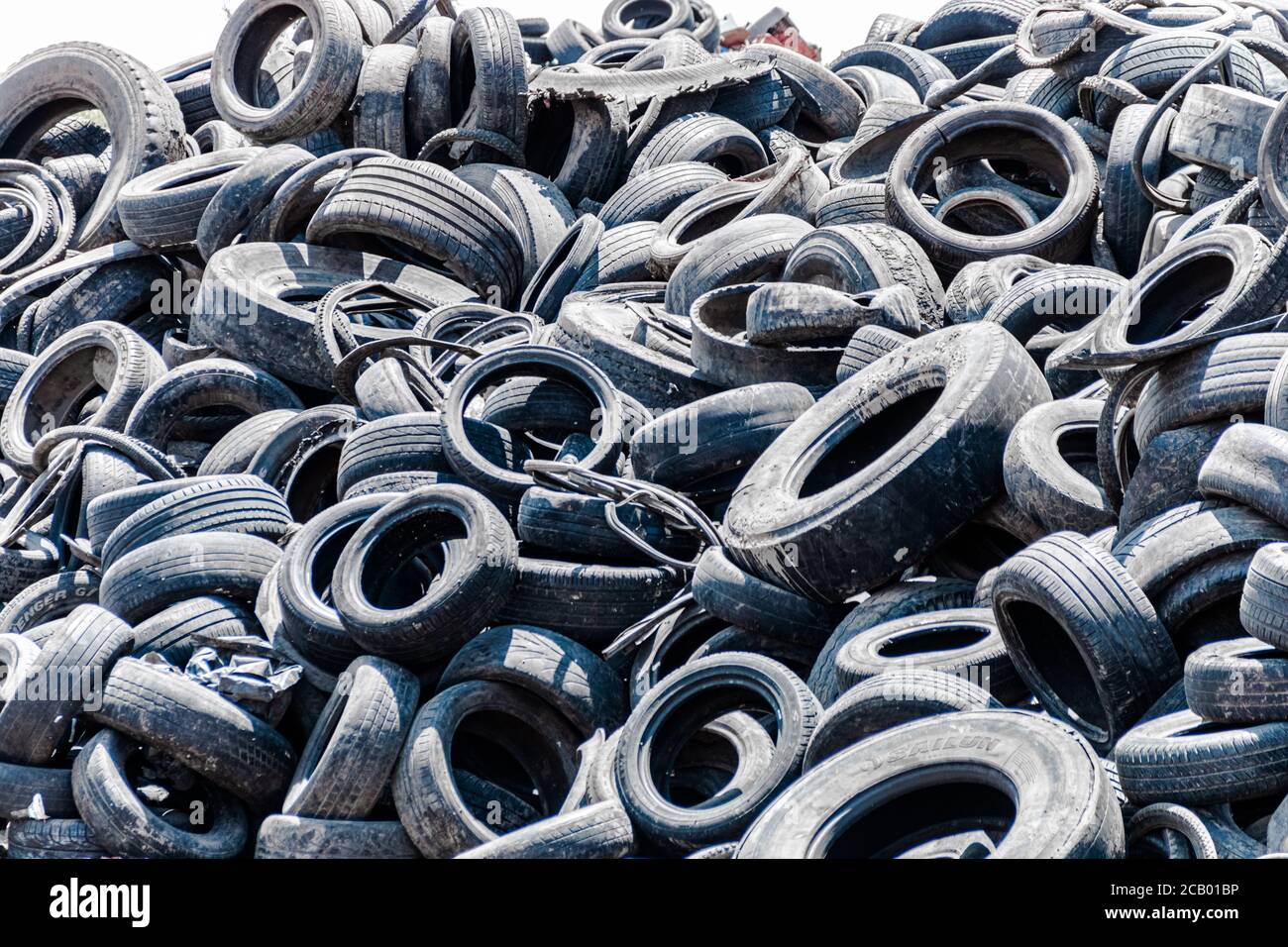 Assorted pile of old and used automotive road tires, showing a Throughout Tire Shop Tread