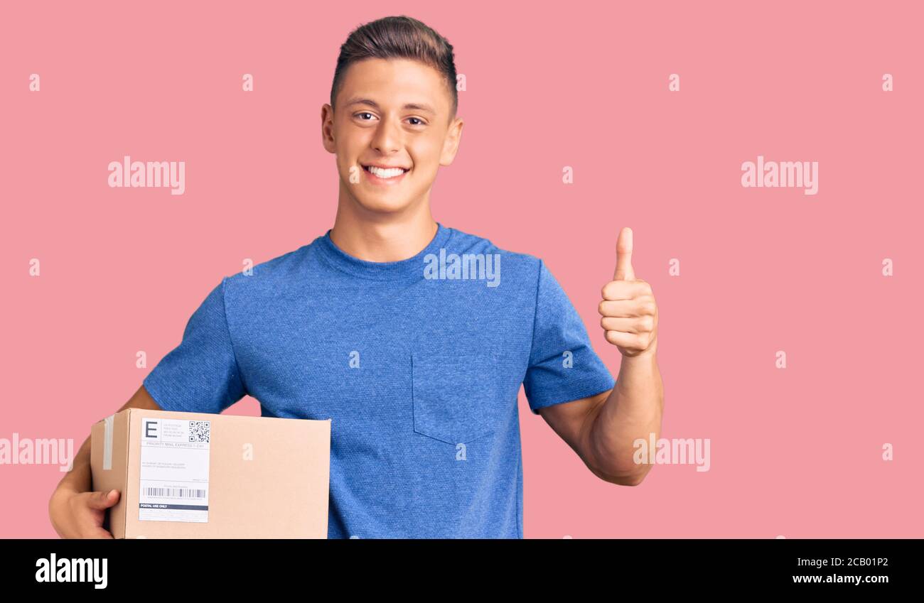 Young handsome hispanic man holding delivery package smiling happy and ...