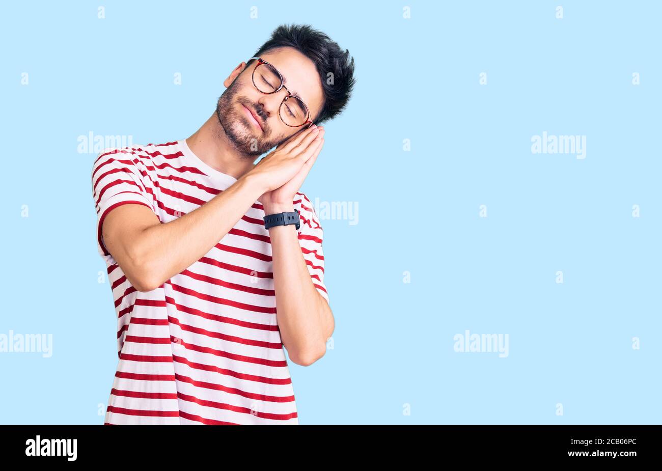 Young hispanic man wearing casual clothes sleeping tired dreaming and ...