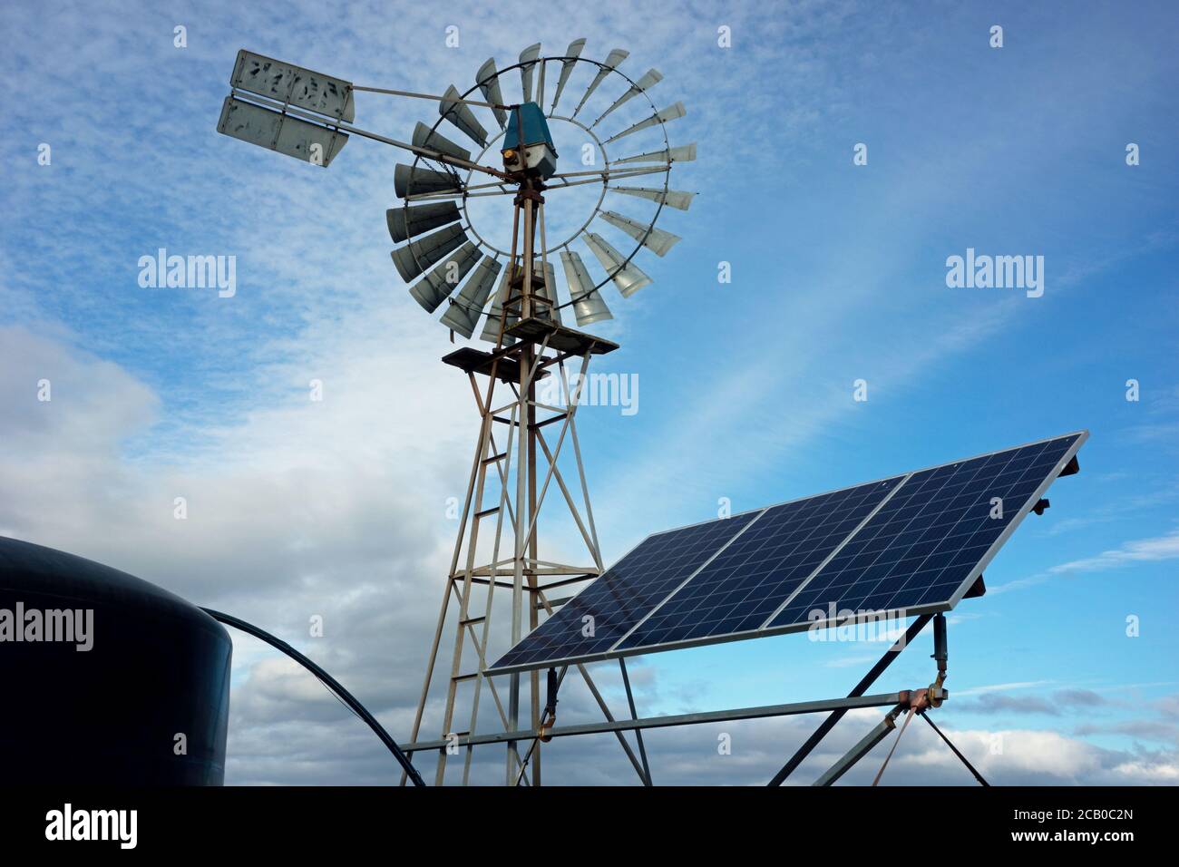 Farm windmill and solar panels with a water tank powered by solar power