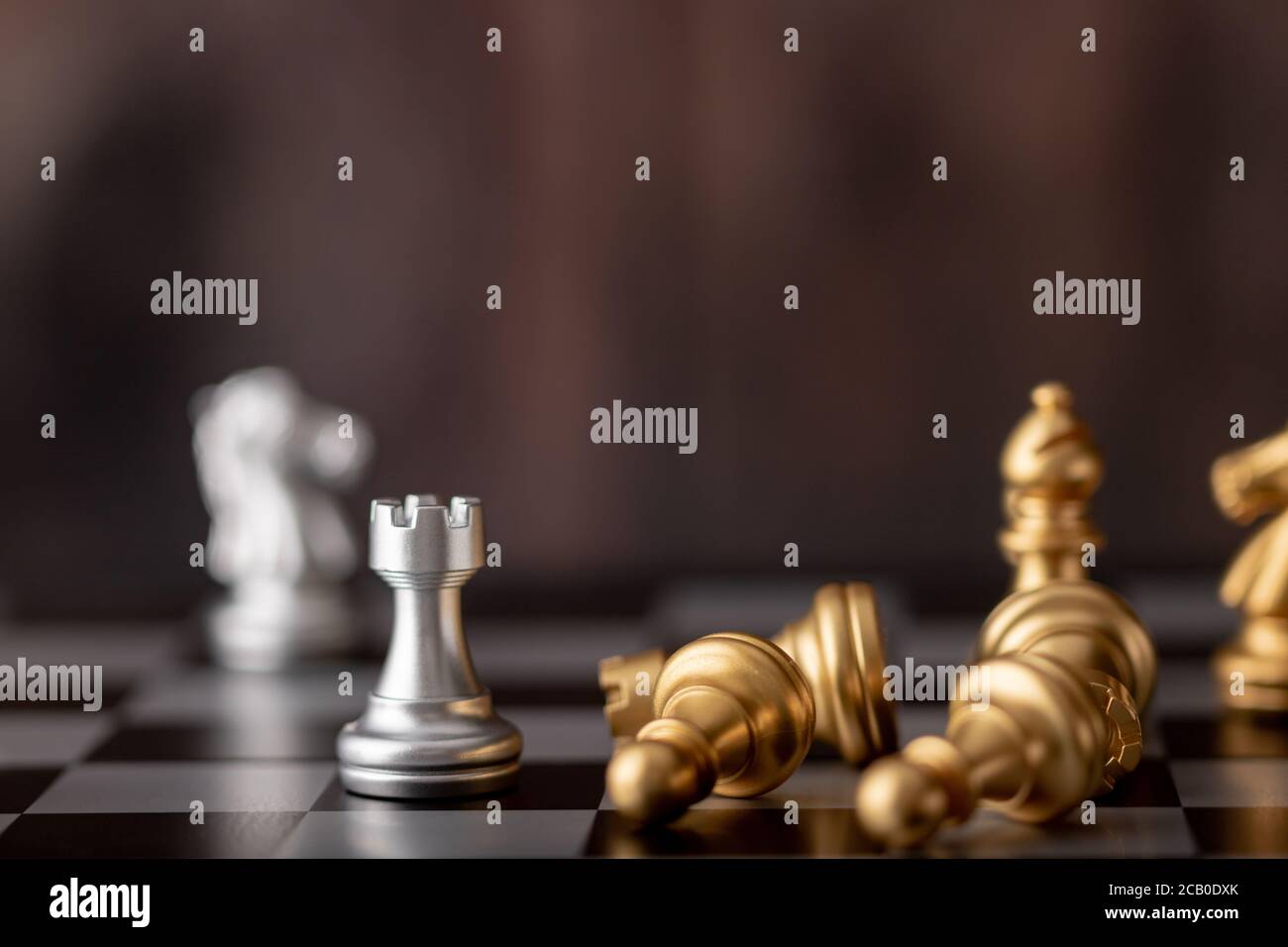 Silver and gold chess on the board and wooden background Stock Photo