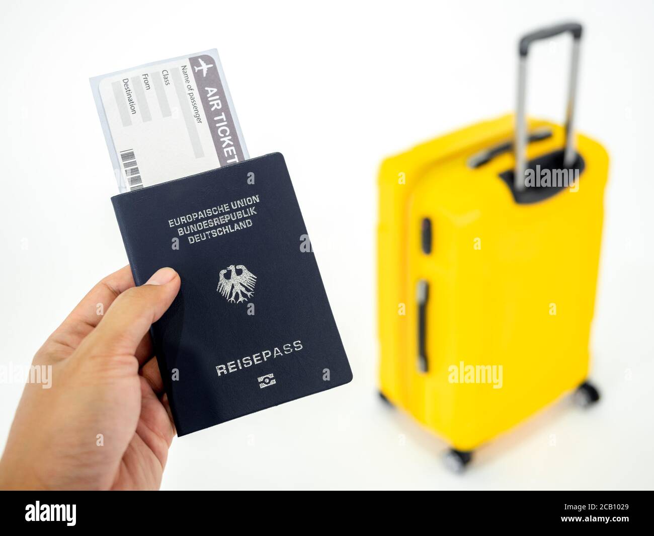 Hand holding passport and airline boarding pass ticket with yellow