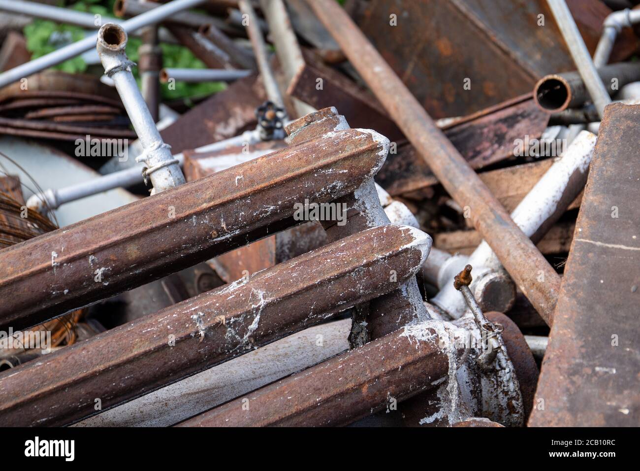 Stack of scrap metal, cast iron radiator in front. Recycling and
