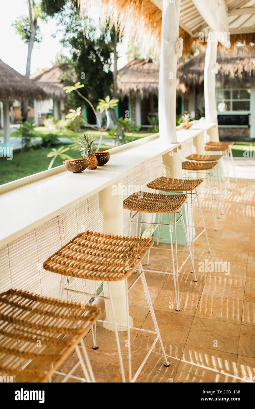 Wicker rattan chairs on bar counter. Trendy furniture design. Summer