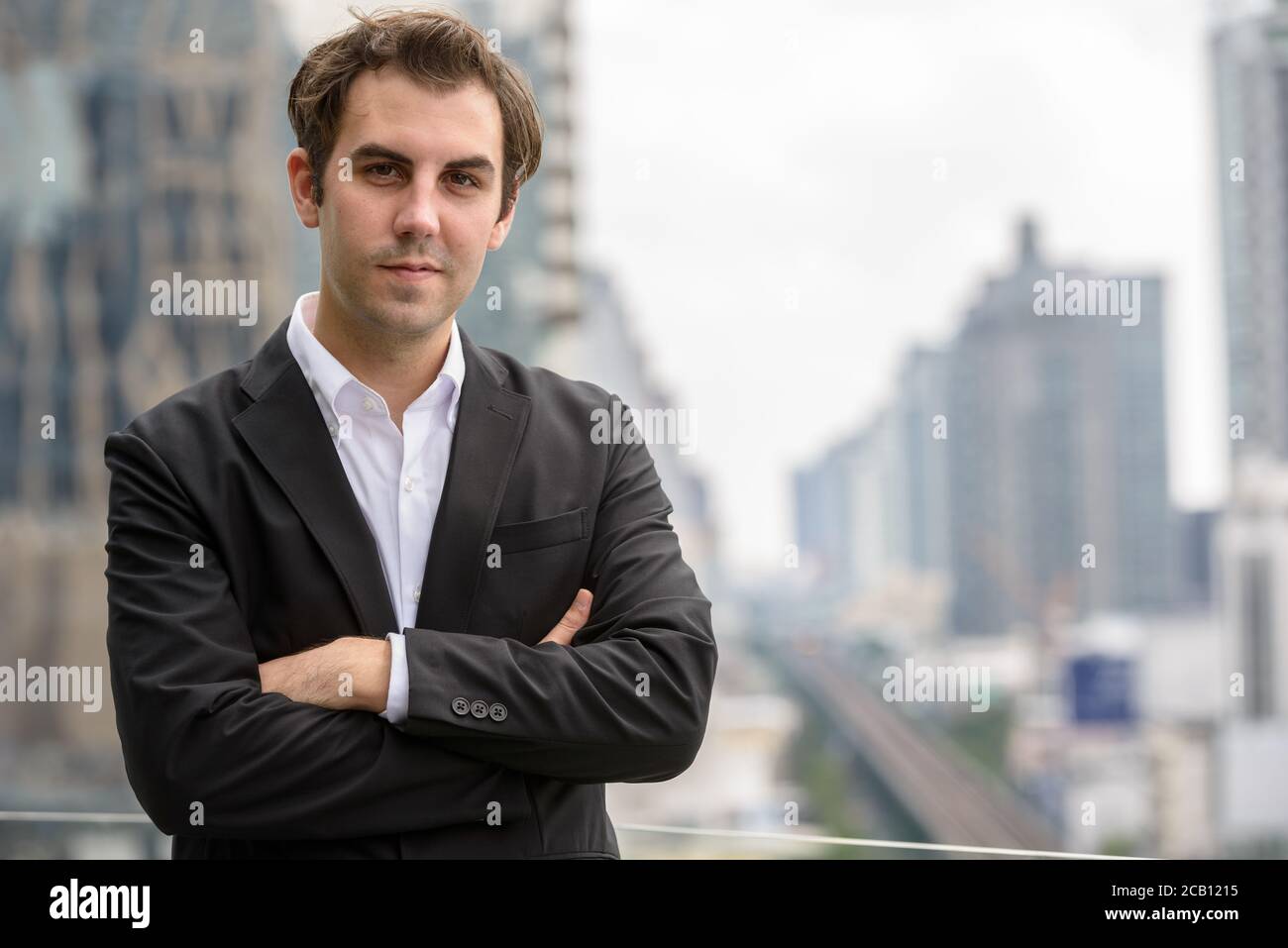 Portrait of businessman in suit against view of the city Stock Photo ...