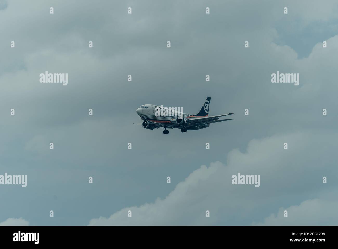 Ho Chi Minh city, Vietnam - 6 Aug, 2020: SF Airlines Boeing 757-200F airplane fly over urban areas preparing landing into Tan Son Nhat International A Stock Photo