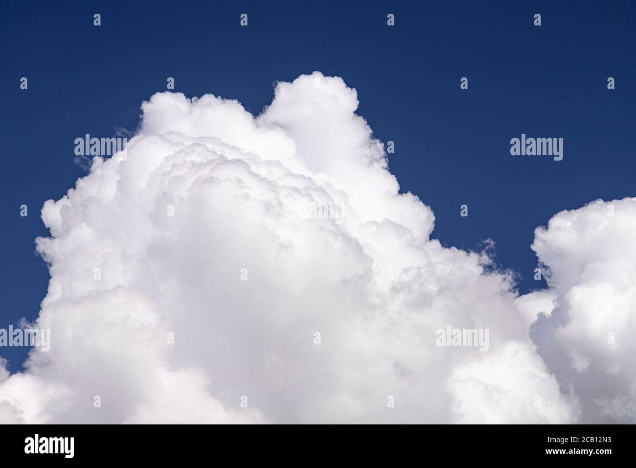 Large cumulus cloud in a deep blue sky Stock Photo