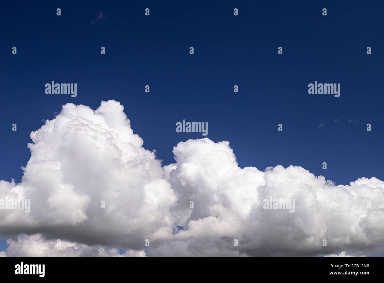 Large cumulus cloud in a deep blue sky Stock Photo