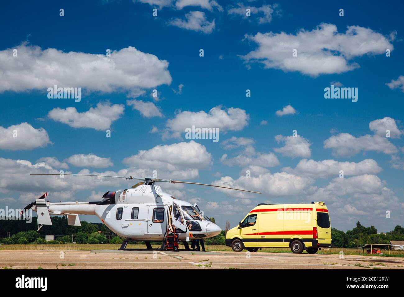 A helicopter and an ambulance are on the runway. Transport concept for medical personnel. Stock Photo