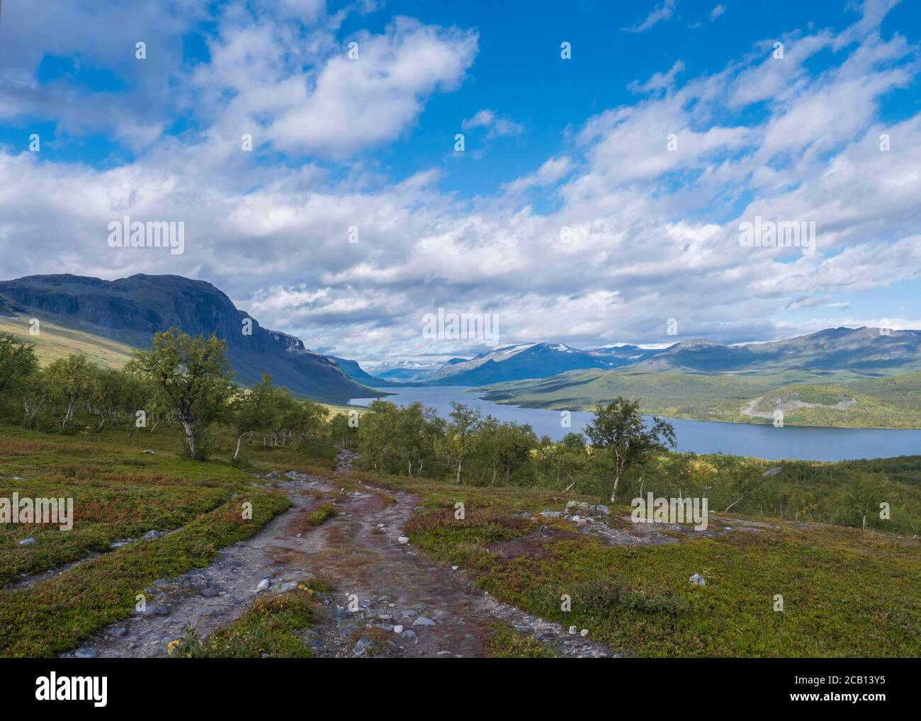 Lapland landscape with beautiful river Lulealven, snow capped mountain, birch tree and footpath of Kungsleden hiking trail near Saltoluokta, north of Stock Photo