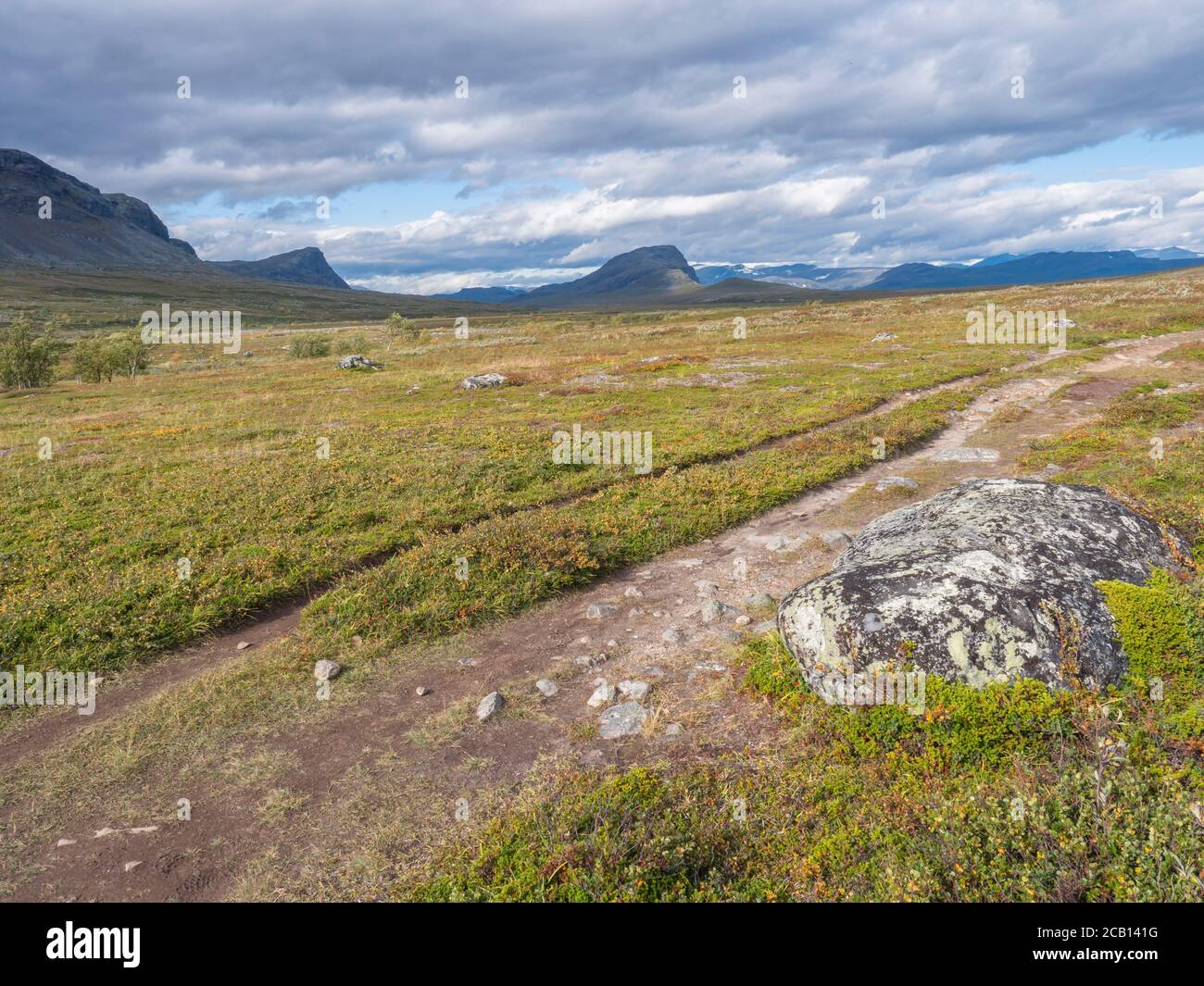 Lapland landscape with Kungsleden hiking trail near Saltoluokta, Sweden. Wild nature with snow capped mountains, autumn colored bushes, birch trees Stock Photo
