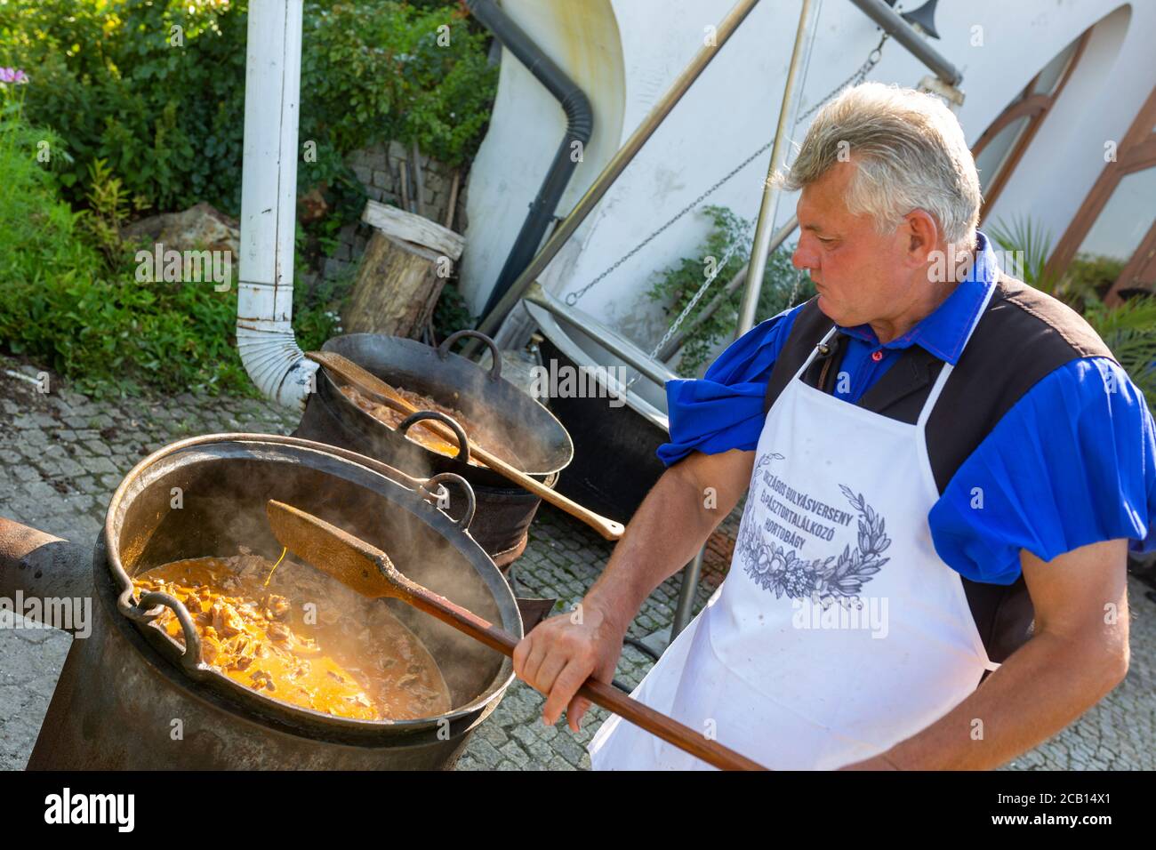 Hungarian wrangler is cooking traditional lamb stew outdoors in a shepherd  convention Stock Photo - Alamy