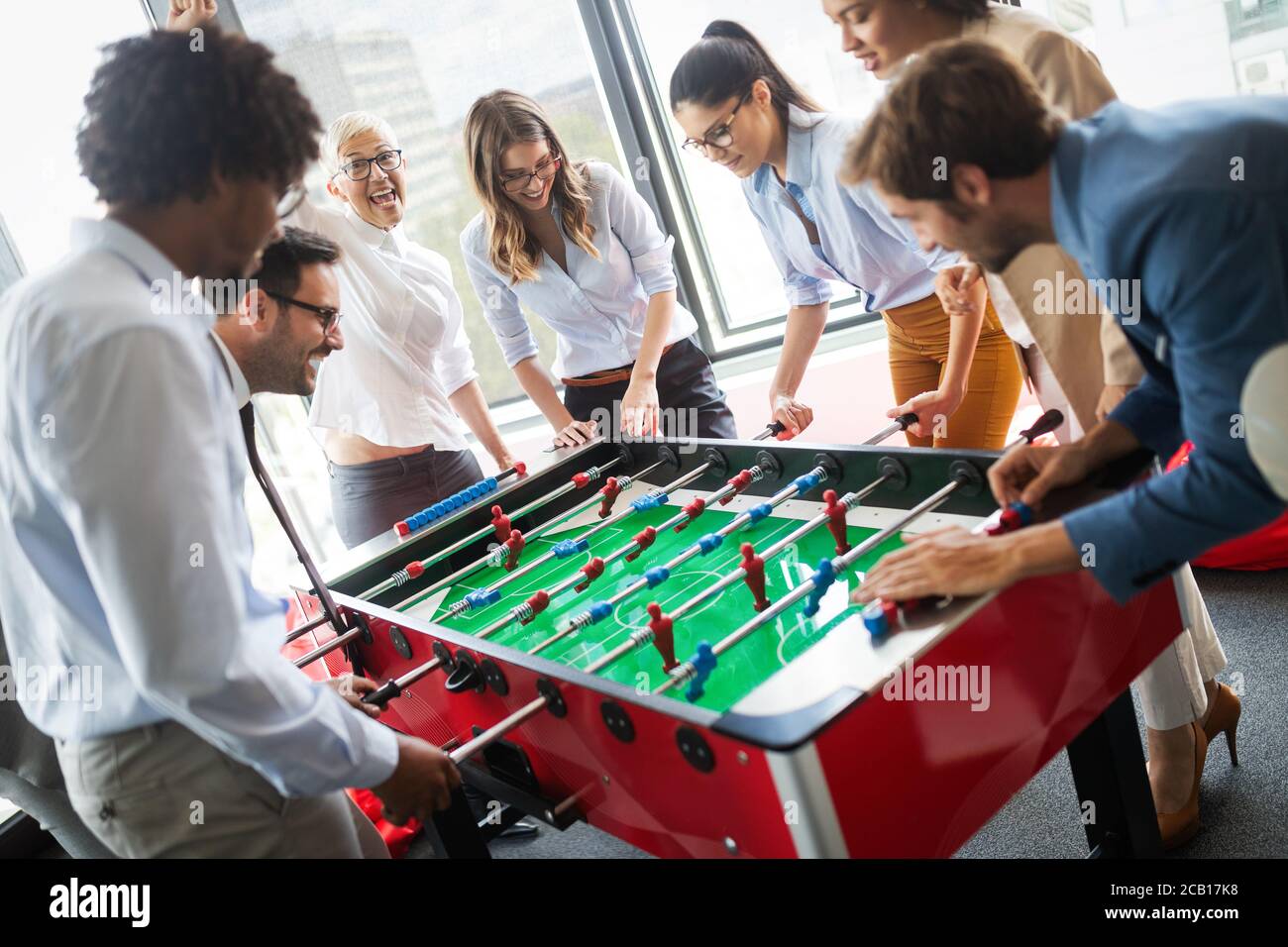 Multiracial people having fun in office room, excited diverse employees