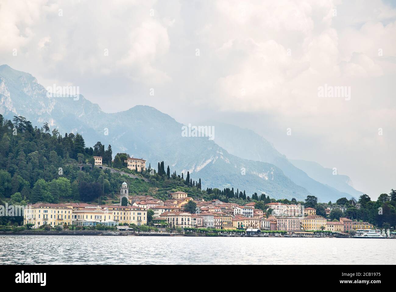 Bellagio City Skyline. Italy. Panoramic View on Lake Como with Alps. Morning. Cloudy Sky. Stock Photo