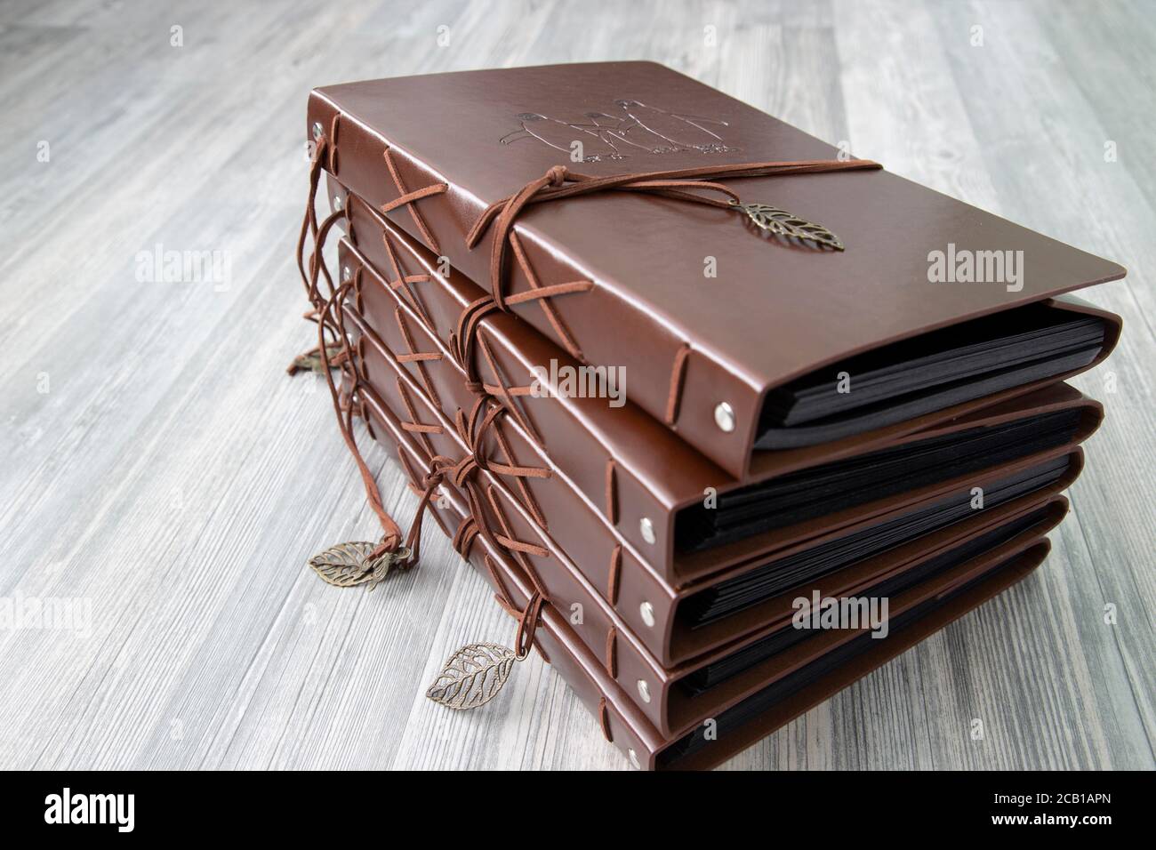 Vintage brown leather photo scrapbook albums on a grey wood
