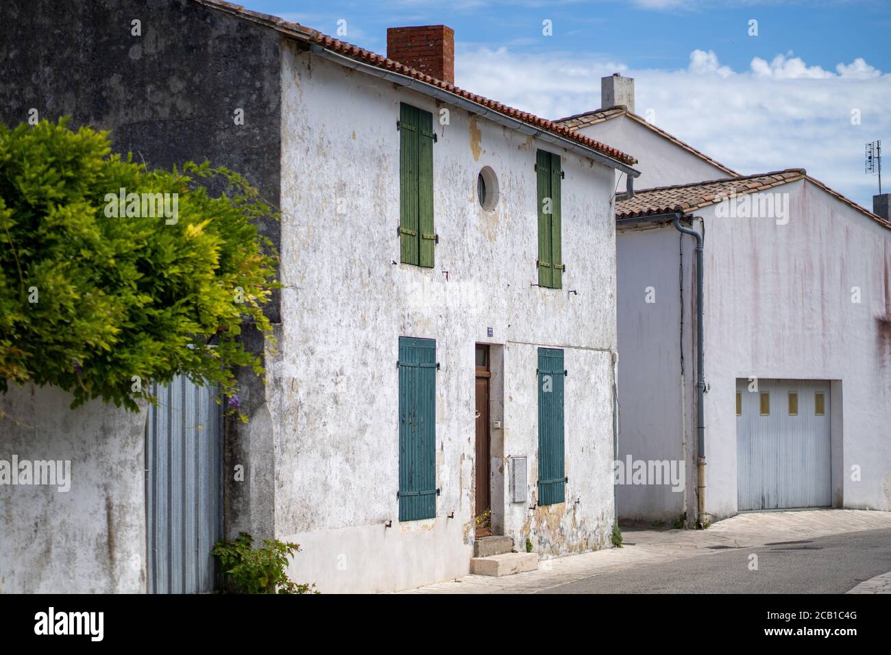 Shot of a stone building with green and blue shutters in Ars-en-re, on the french Re island Stock Photo