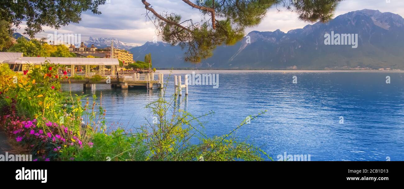Panoramic sunset banner of Lake Geneva, Switzerland from Montreux promenade with colorful flowers, mountains behind Stock Photo