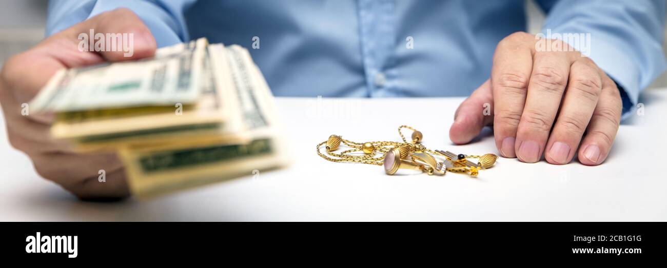 Buying gold jewelry, us dollars and hand of a businessman, panorama, bodypart hands Stock Photo
