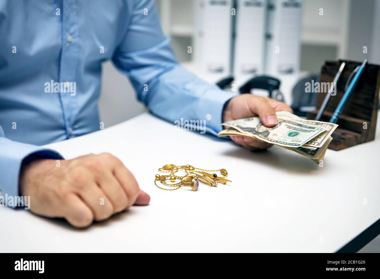 Man buying gold jewellry, pawn shop and us dollar banknotes Stock Photo