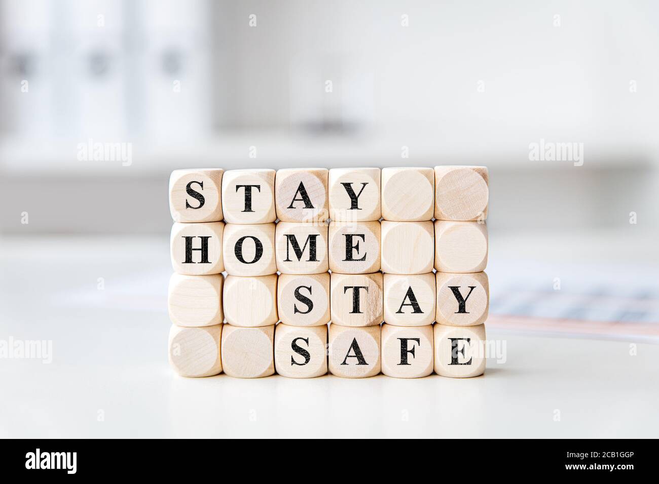 many wooden blocks in a bright office or practice with the words stay home stay safe Stock Photo