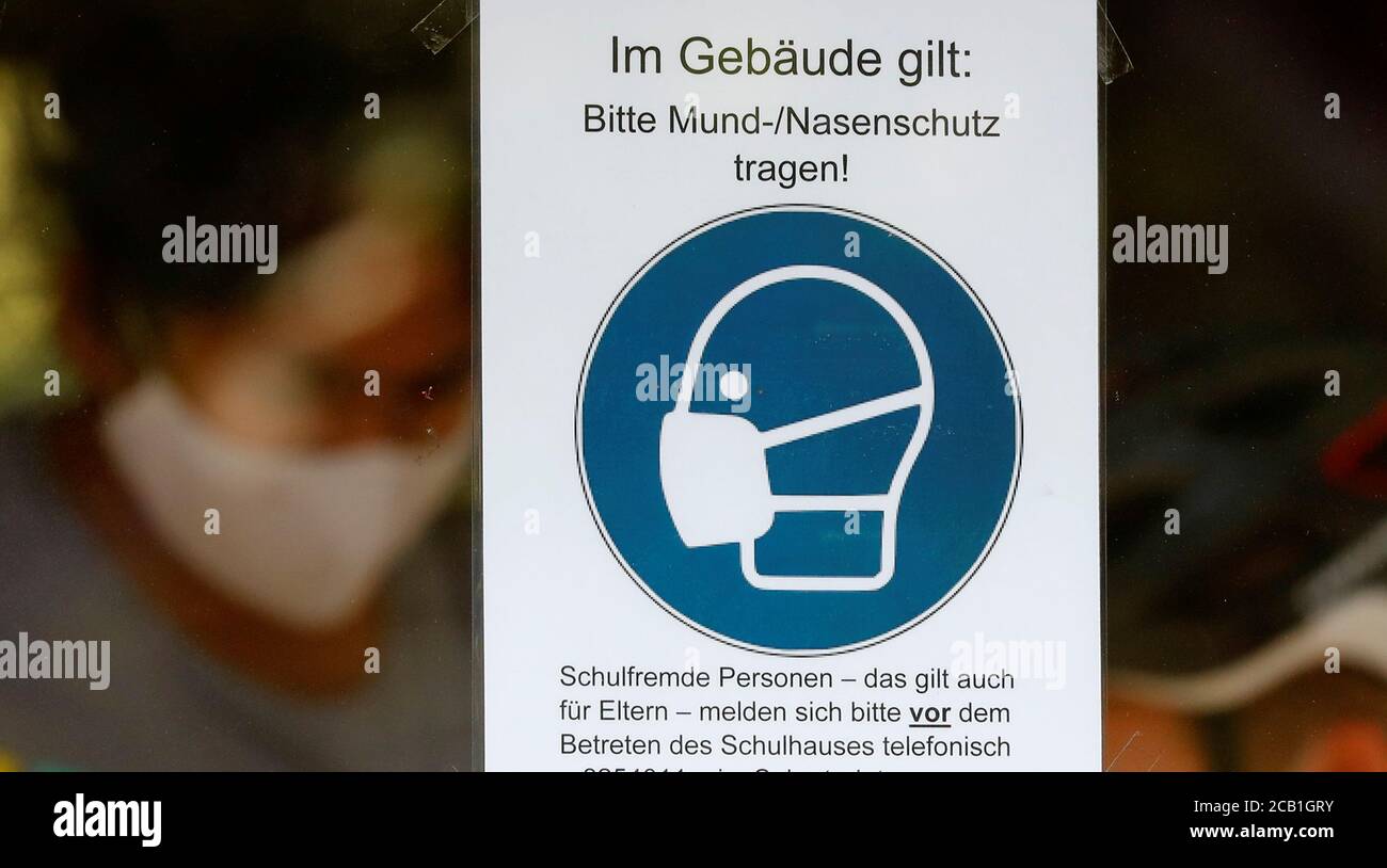A sign advising to wear face masks is seen at the protestant high school  "Zum Grauen Kloster", on the first day of classes after the summer  holidays, amid the coronavirus disease (COVID-19)