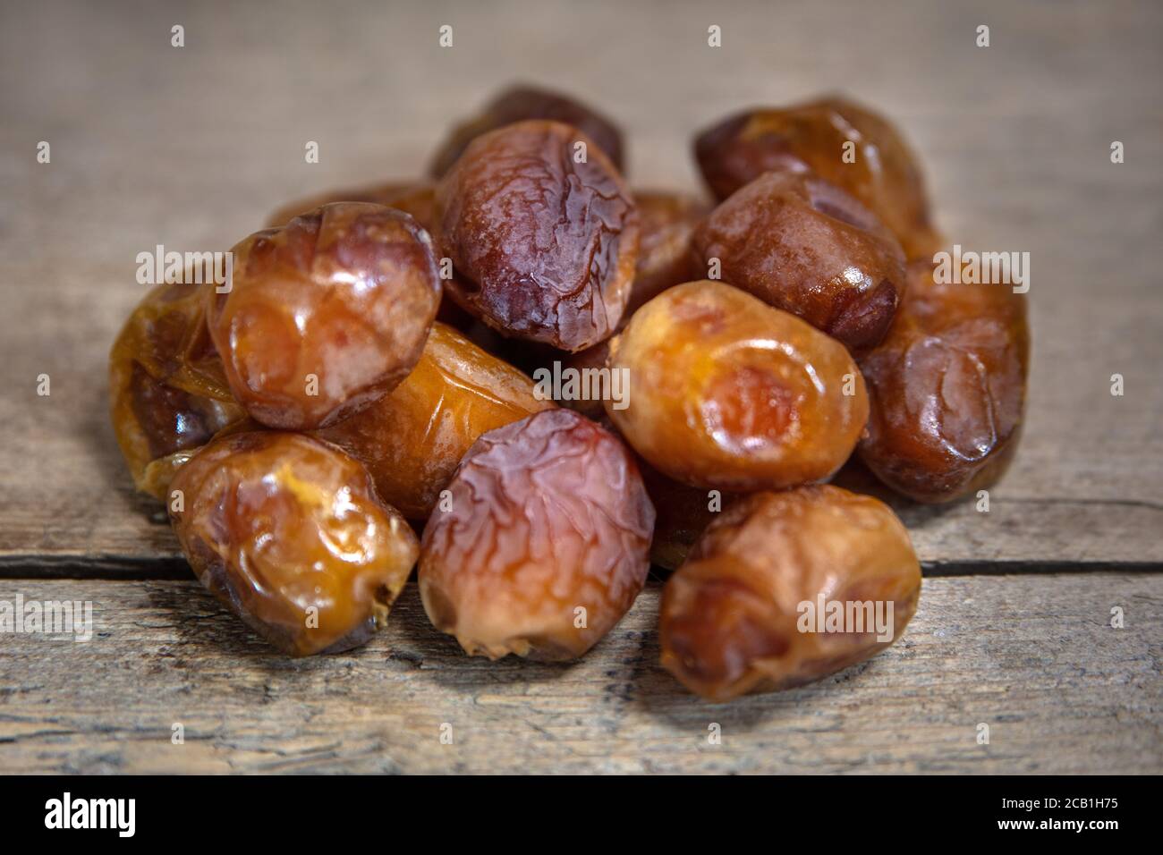 Dried dates on wooden table, sort soft bawalini, sweet vegan superfruit Stock Photo