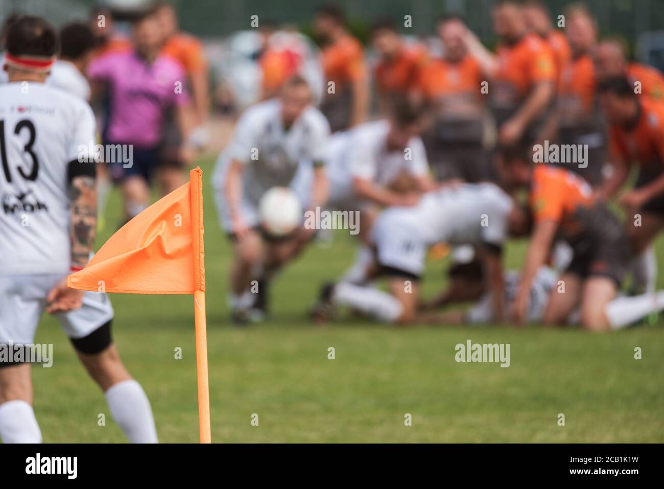 Flag on the pitch with rugby match in the background. Stock Photo