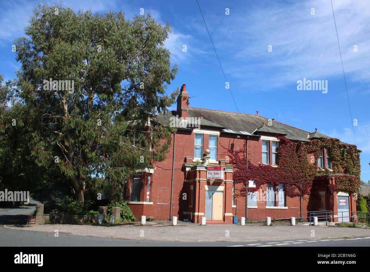 View of the front of the closed Golden Ball pub in Pilling, Lancashire with shutters at the windows, door boarded up and for sale sign above entrance. Stock Photo