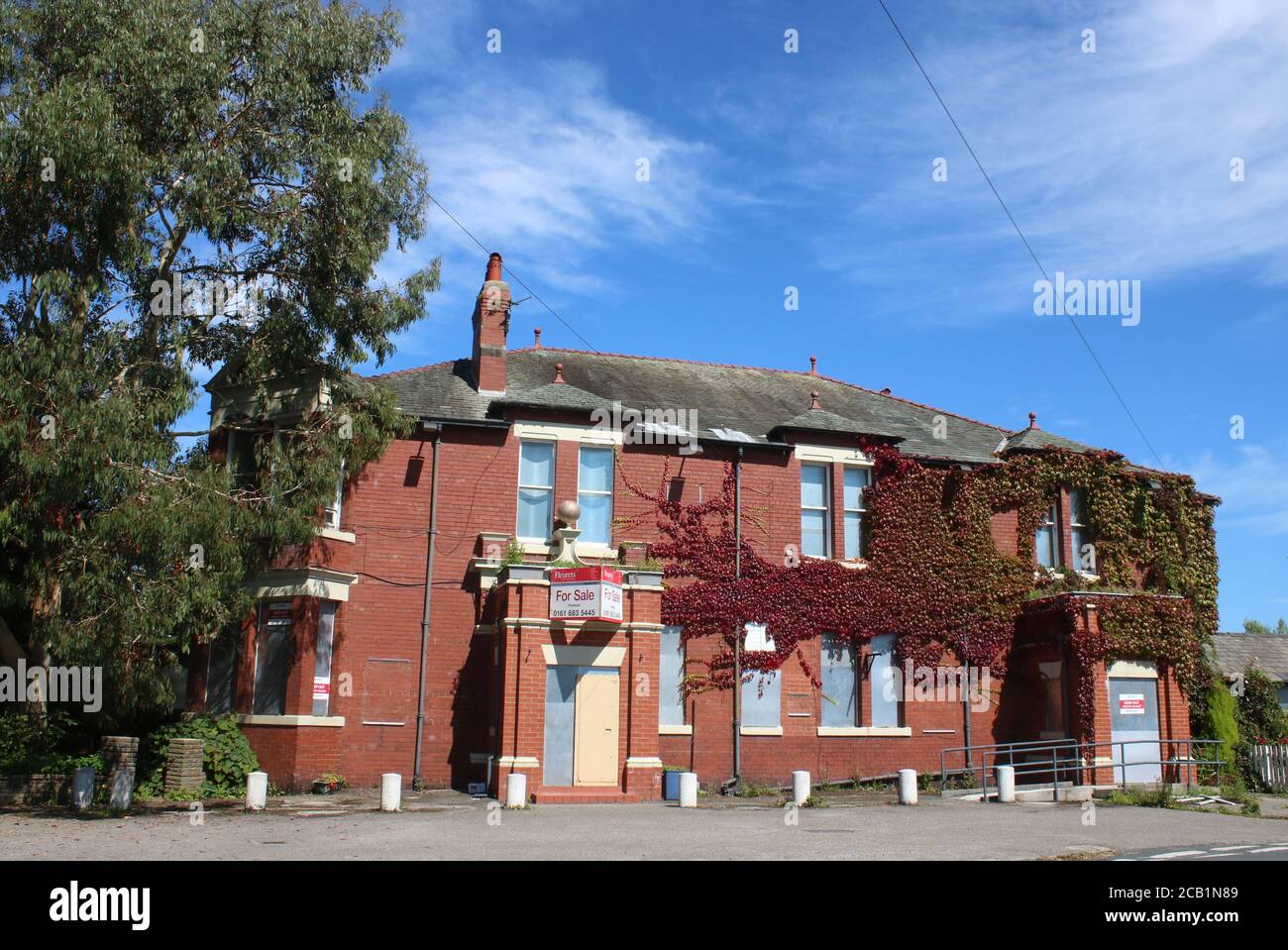 View of the front of the closed Golden Ball pub in Pilling, Lancashire with shutters at the windows, door boarded up and for sale sign above entrance. Stock Photo