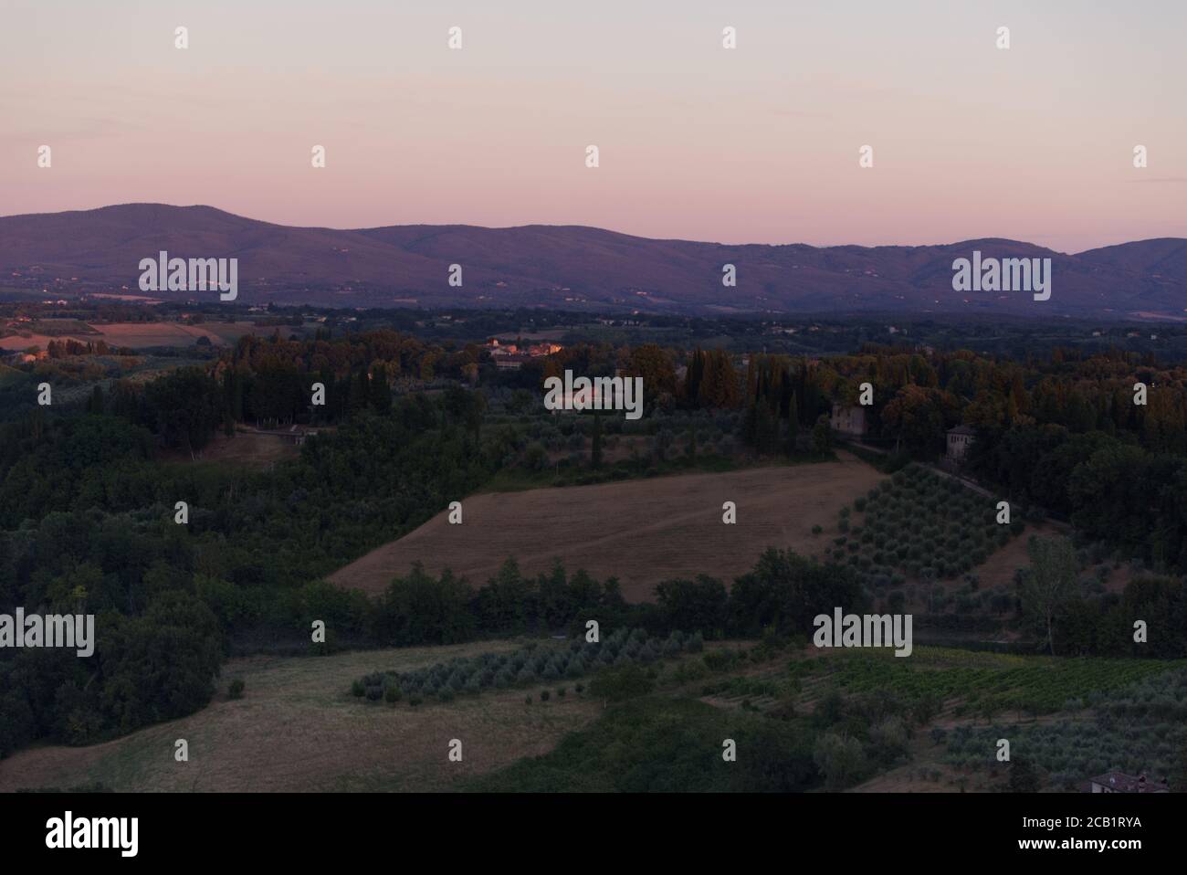 Evening lights on the Tuscan landscape, view from the town of San Gimignano Stock Photo