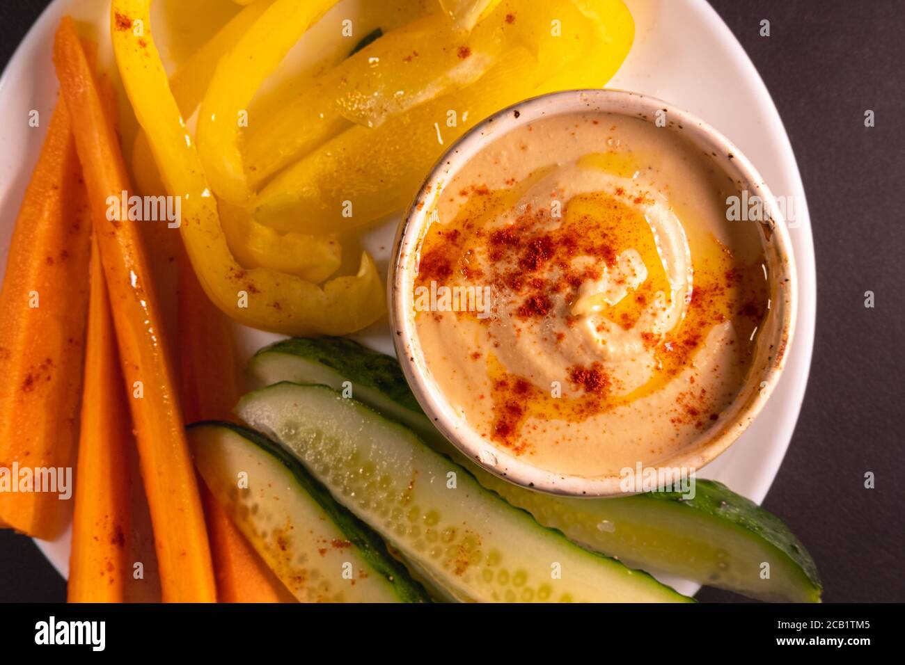 Hummus dip and vegetables on a plate, top view with copy space. Healthy vegan meal or appetizer, plant based and vitamin rich food Stock Photo