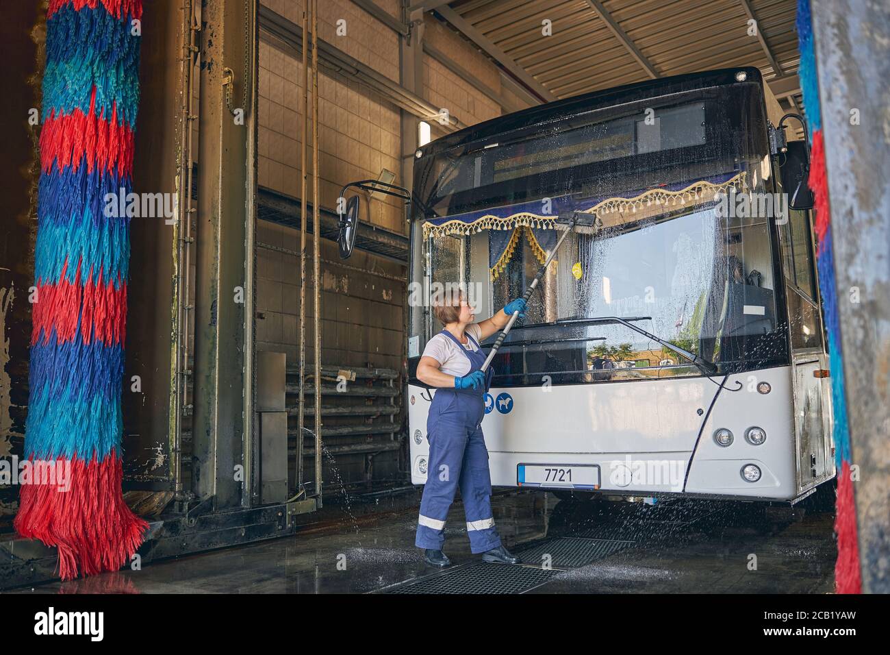 Conscious female washing windshield at car wash Stock Photo Alamy