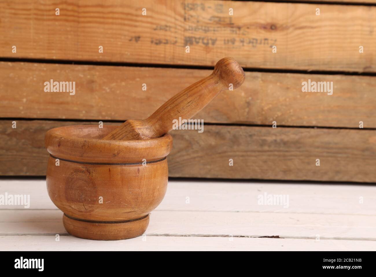 Wooden herb pounder on wooden background Stock Photo - Alamy
