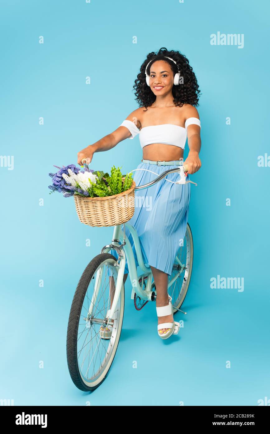 Gentagen Forkorte selvbiografi happy african american girl in headphones riding bicycle on blue, summer  concept Stock Photo - Alamy