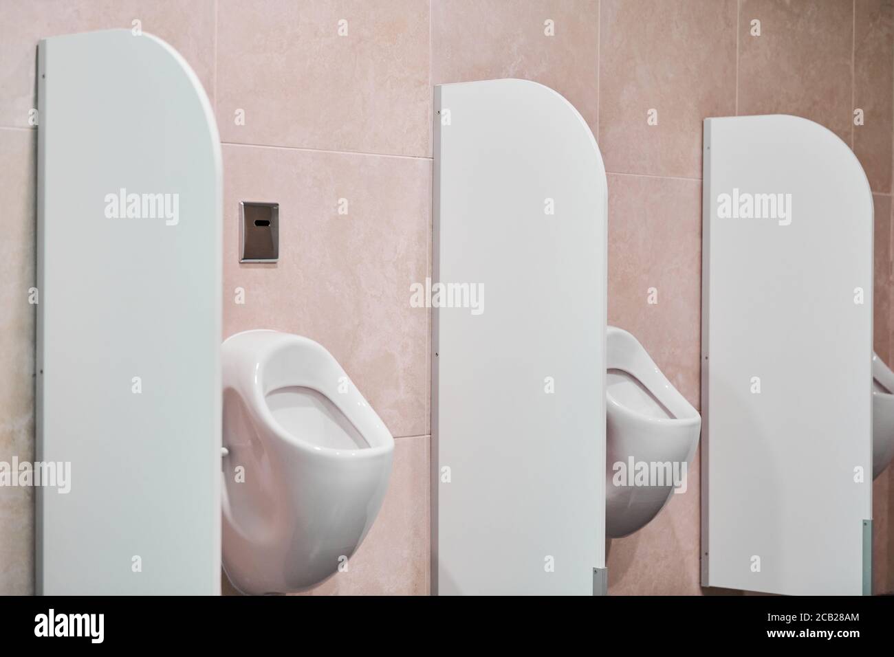 Urinal in public men toilet. Urinal with privacy barriers and flush