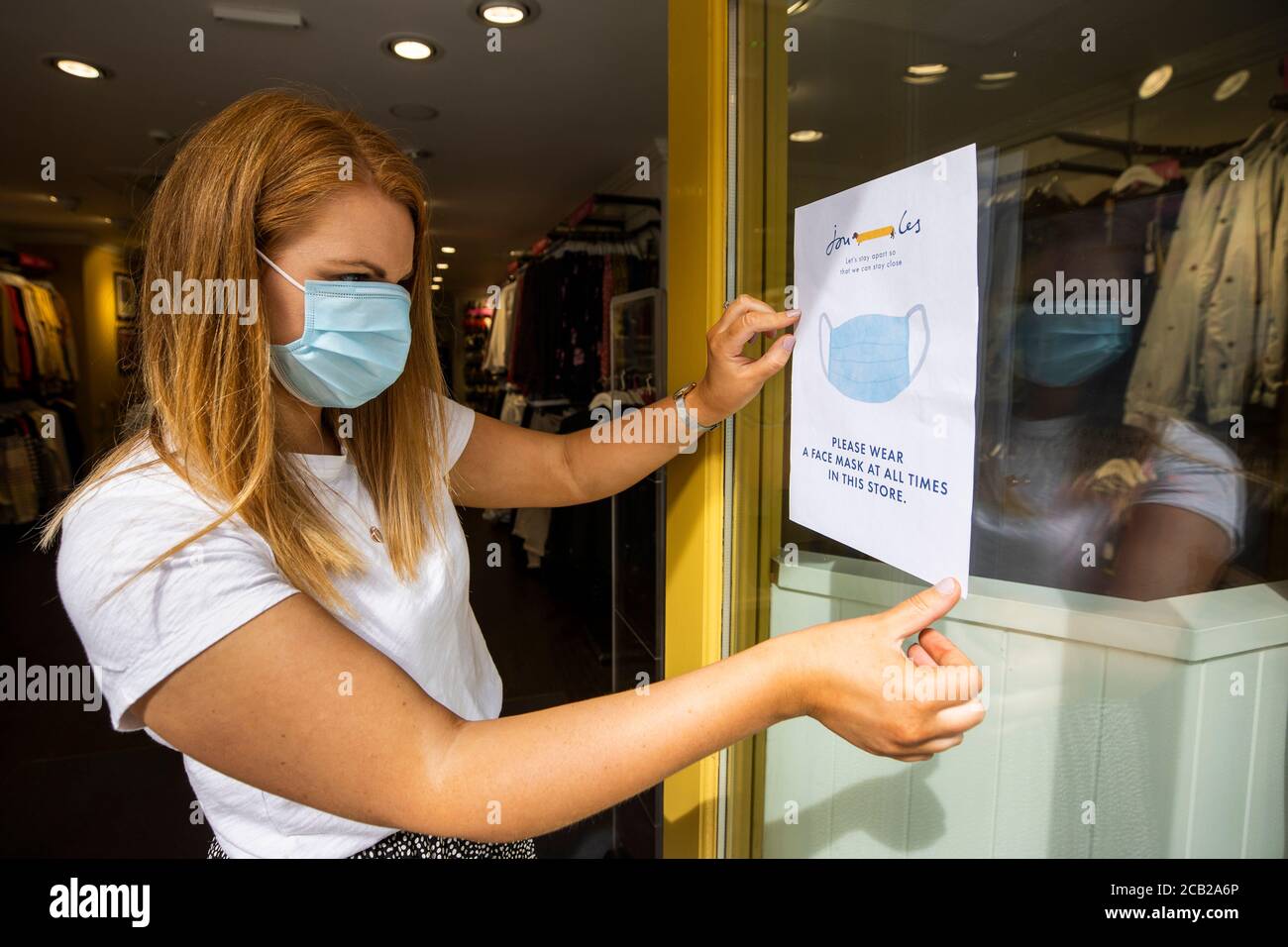 Joanne Millar store manger of Joules in Belfast places a sign in the