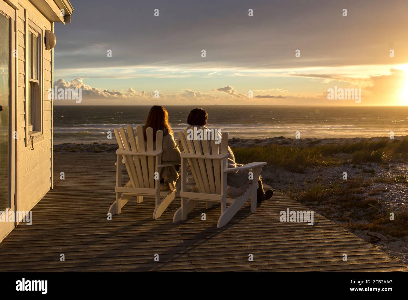 Romantic Couple Enjoying Sunset At Beach House Stock Photo Alamy