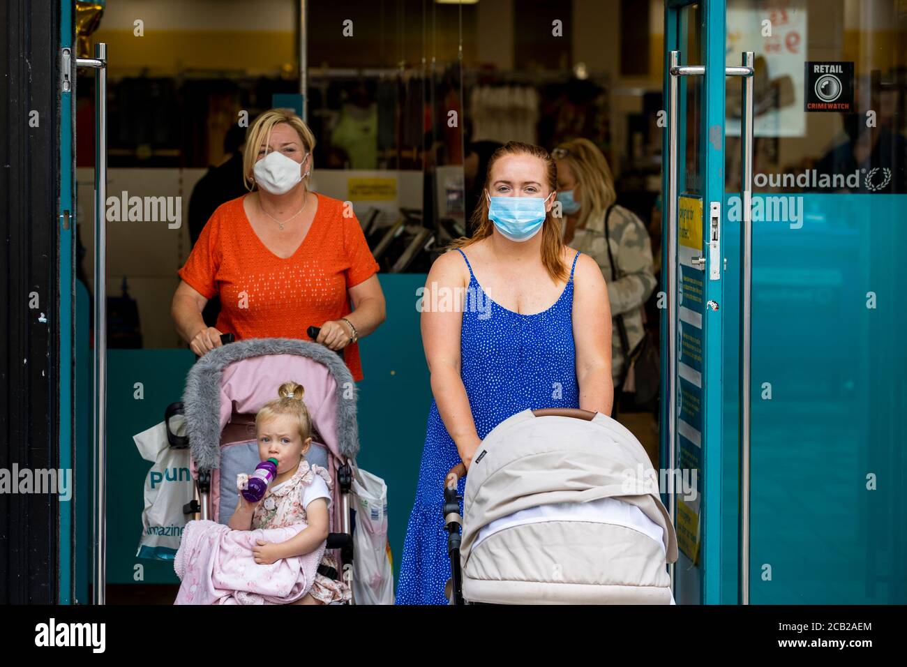 Customers wearing face masks leave Poundland in Belfast as face